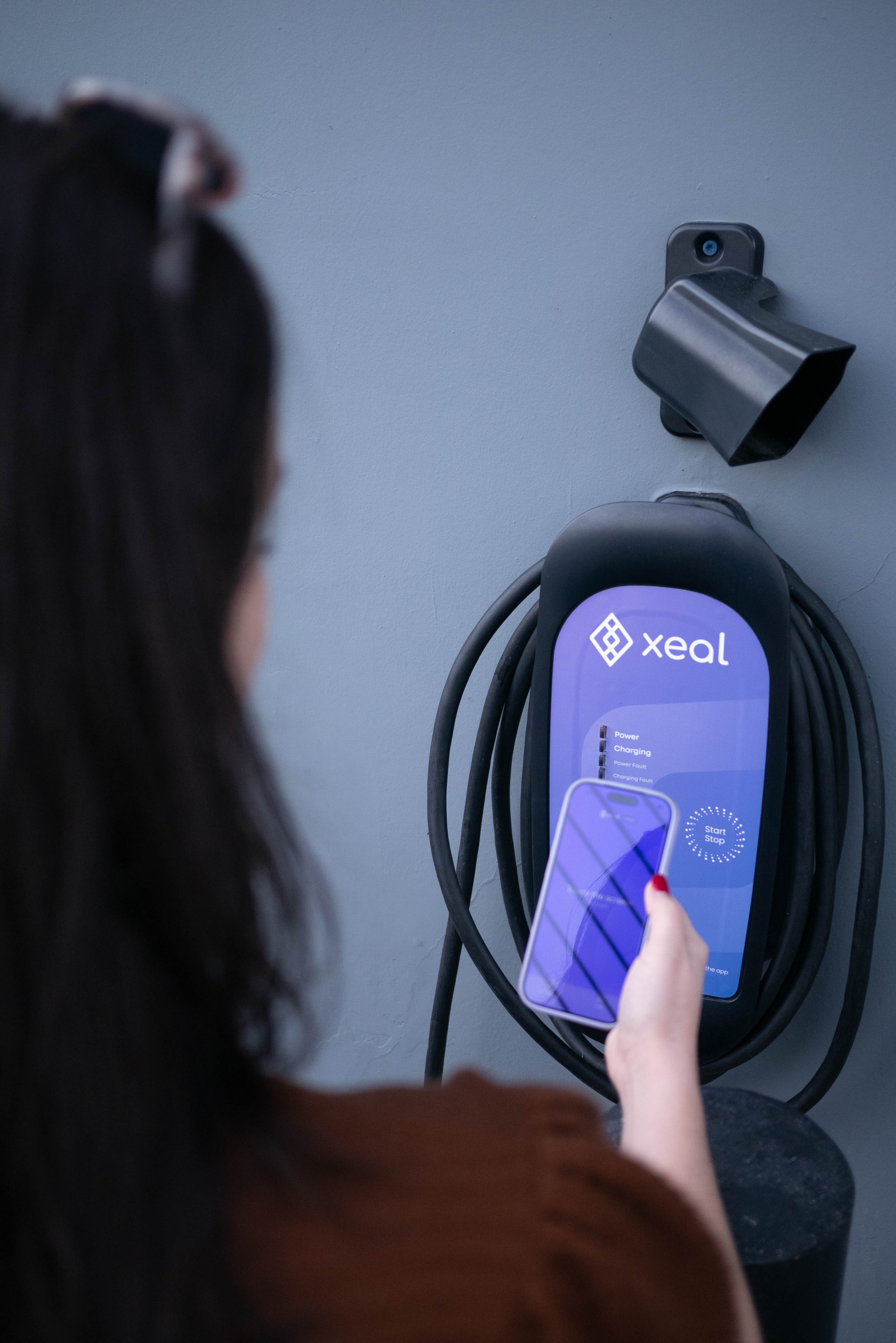 A driver starting a charge from the Xeal app