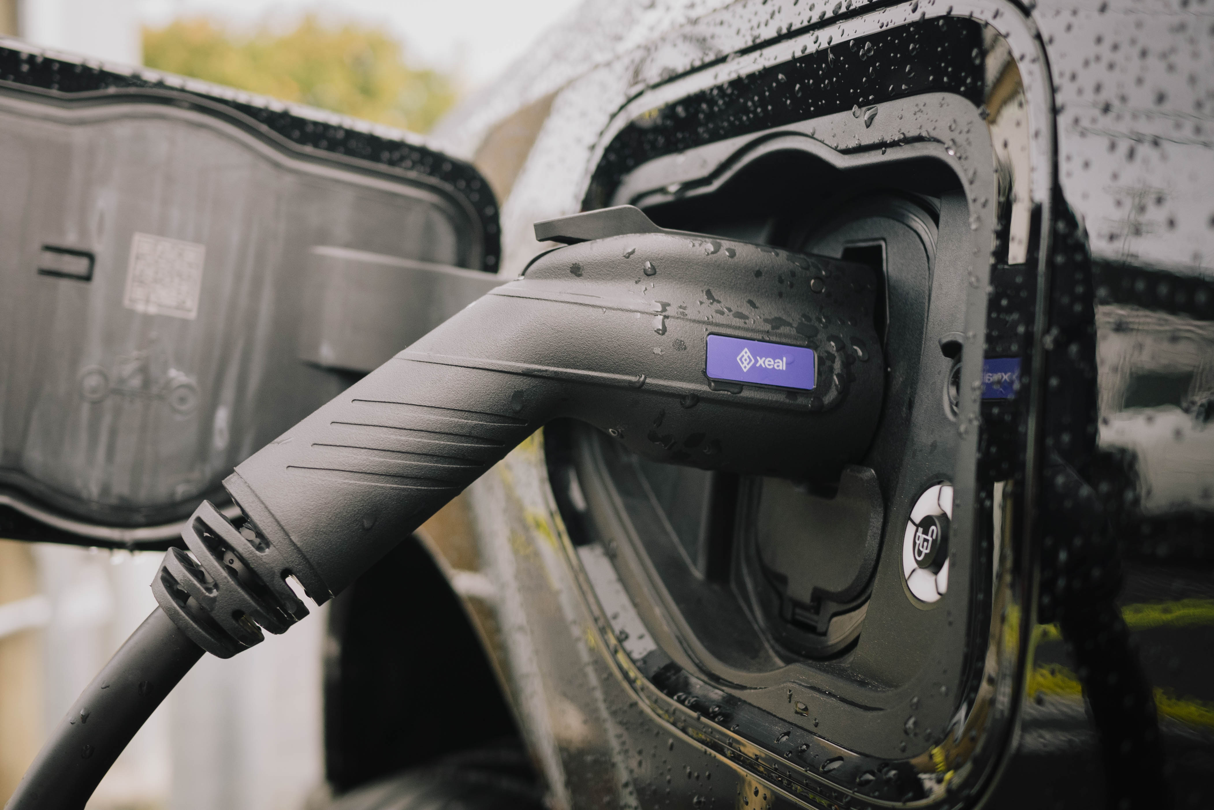 A Xeal connector plugged into a vehicle in the rain